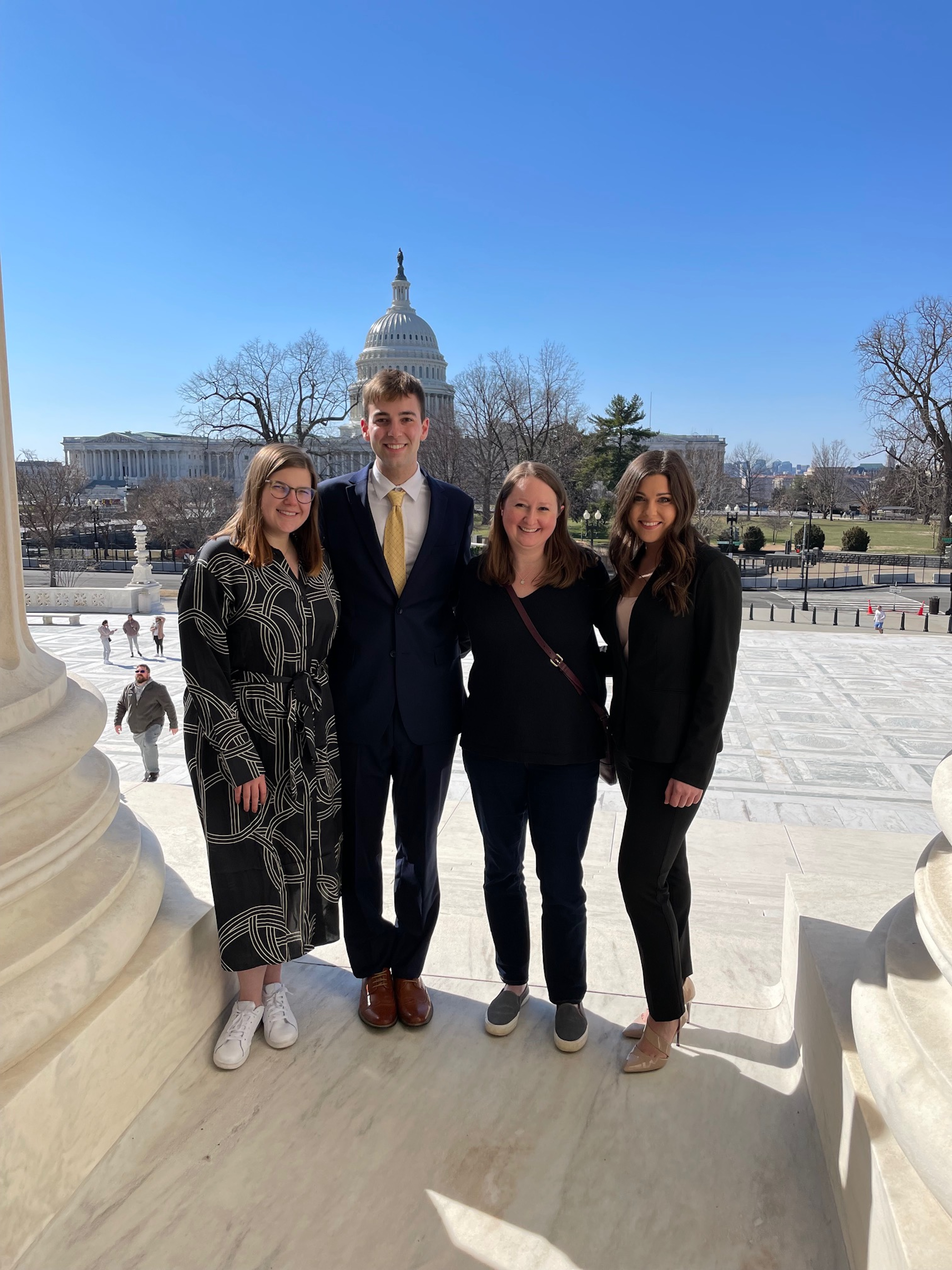 Laura Kate Smith (‘23), Cameron Dobbs (‘23), Megan Walsh (‘12) Director of DC Externships, and Analeigh Barnes (‘22) pose on the steps of the Supreme Court, overlooking the Capitol Building. 