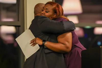 Alabama Law BLSA President Camdyn Neal hugs Professor Fair after announcing that the executive board has renamed the chapter in honor of Professor Fair.